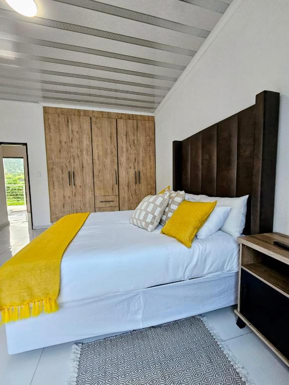 a bedroom with a large bed with a yellow blanket at KLAAK hotel and Apartments in Ga-Masamothane