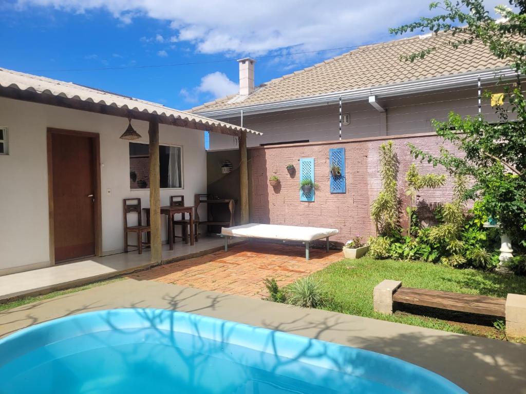 ein Hinterhof mit Pool und Haus in der Unterkunft Pousada Canto das Estrelas in Chapada dos Guimarães