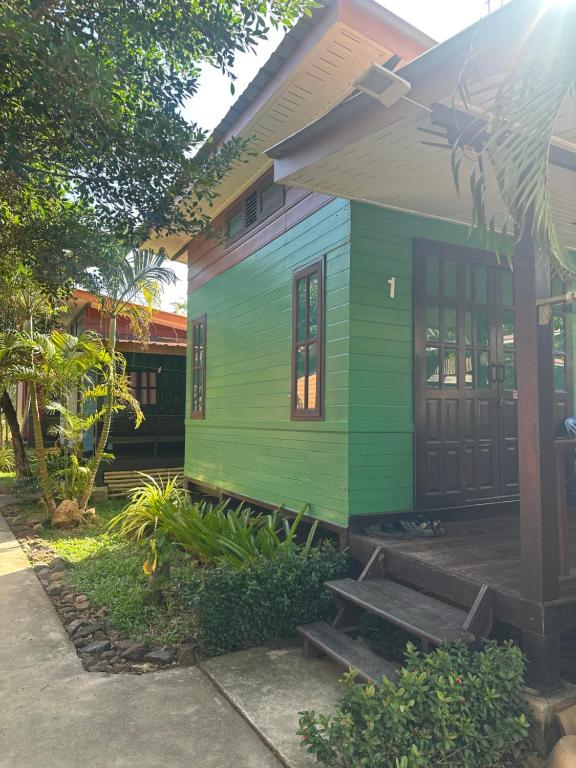een groen en blauw huis met een veranda bij DD Beach Houses in Phra Ae beach