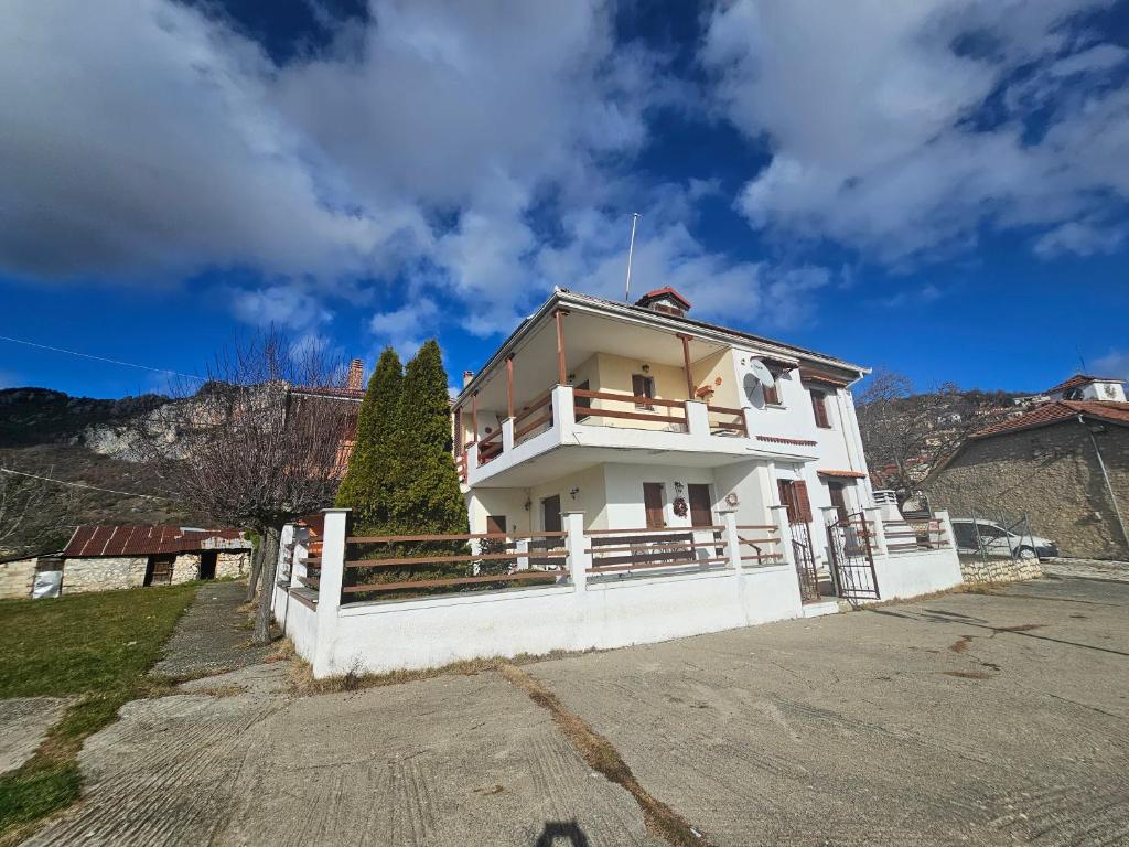 a white house with a fence in front of it at Portitsa View Guesthouse in Spílaion