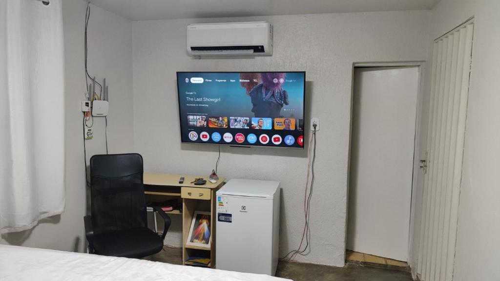 卡雅泽拉斯Qt bem localizado e Confortável -Centro的客房设有书桌和墙上的电视。