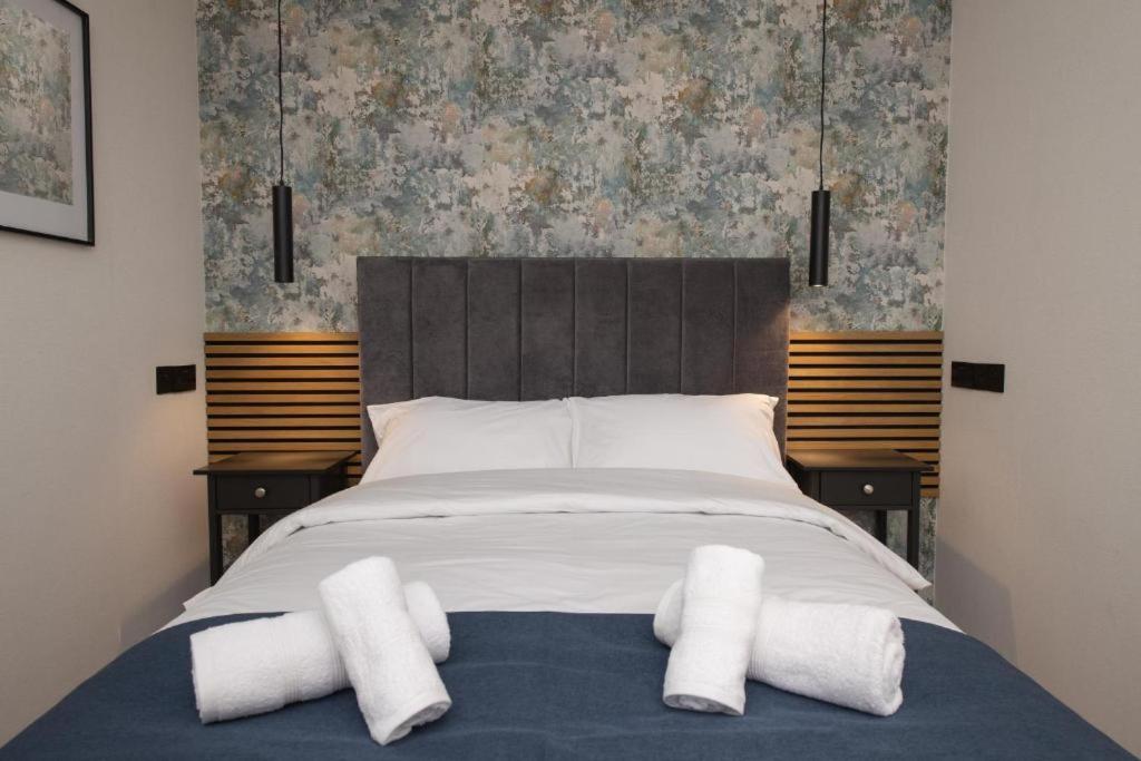 ein Schlafzimmer mit einem Bett mit zwei weißen Handtüchern darauf in der Unterkunft Amber Hotel Double Room in Hull