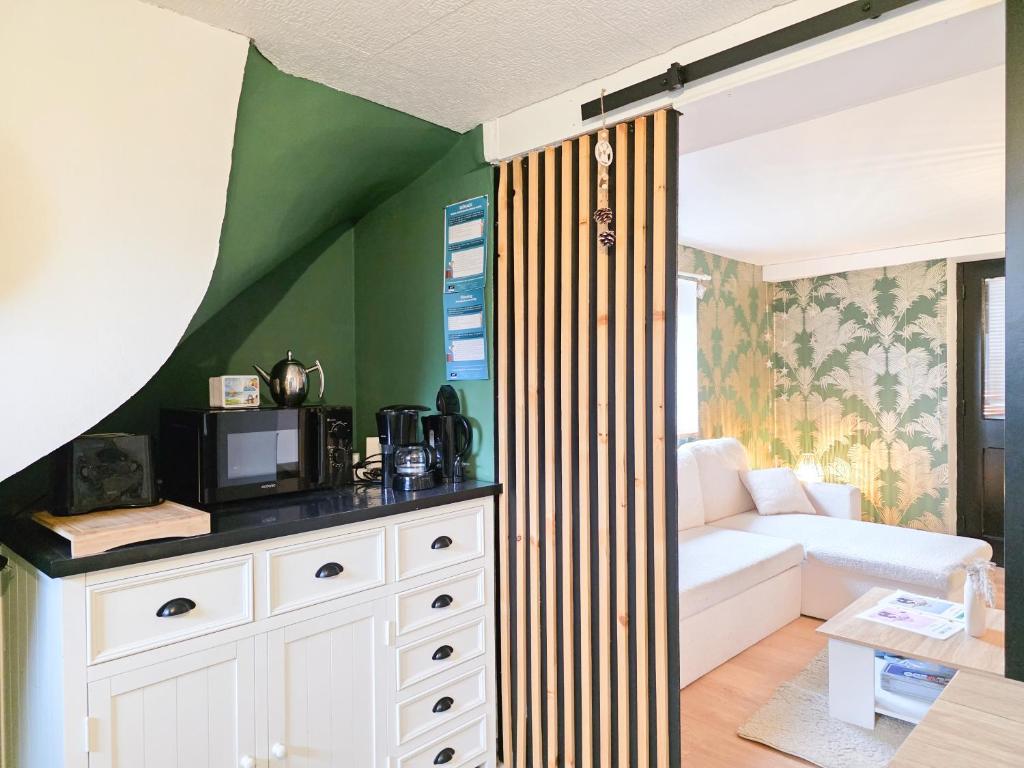 een woonkamer met een bank en een tv bij Aux Berges Du Mont - Parking, 10 min Mont-Saint-Michel & Jardin in Pontorson