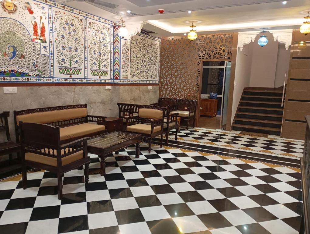 a lobby with chairs and a checkered floor at Hotel Har Niwas udaipur city of lakes in Udaipur