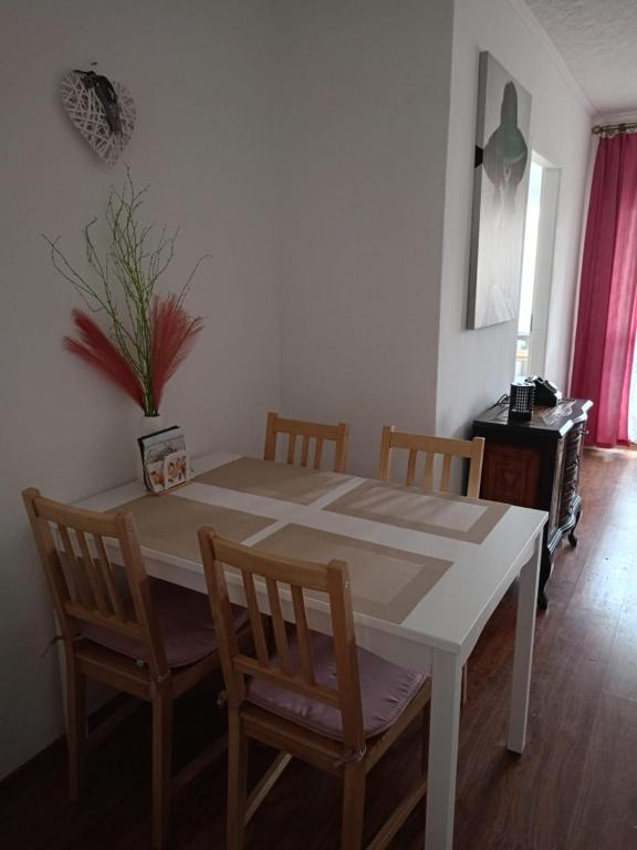 a dining room table and chairs with a table and a plant at Hel - Apartament in Hel