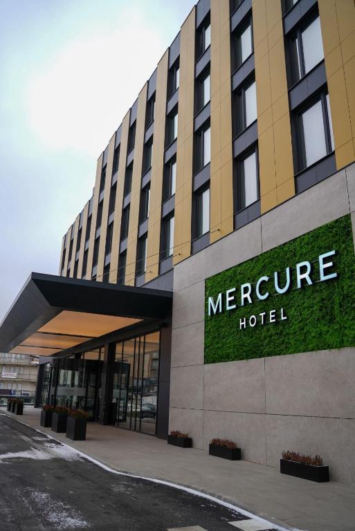a large hotel building with a sign on it at Mercure Prishtina City in Prishtinë