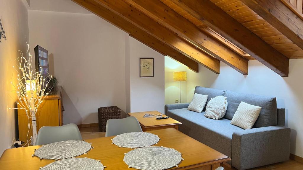 een woonkamer met een blauwe bank en een tafel bij Casa La Muga in Benasque