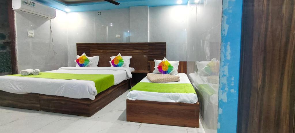 a bedroom with two beds with green sheets at Hotel Gloria Rishikesh in Rishīkesh