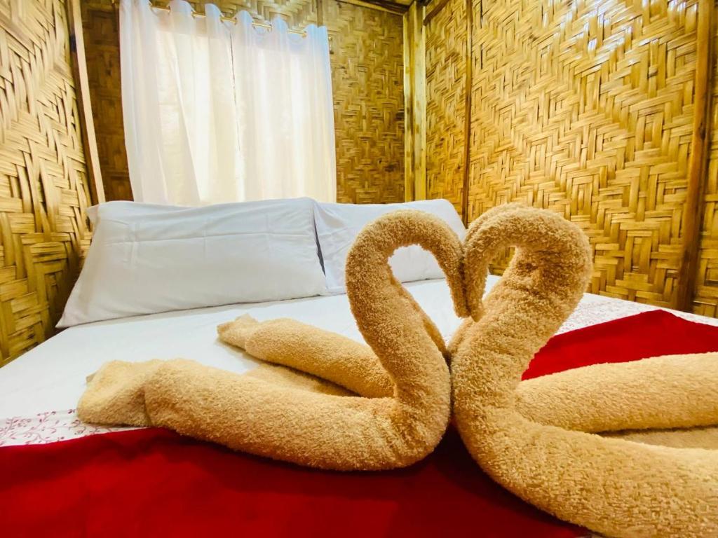 two towel swans sitting on top of a bed at The Tribe Apartment in Port Barton