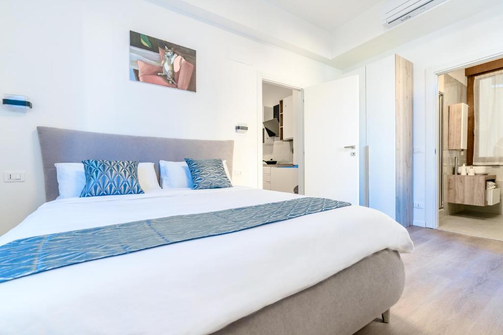 a bedroom with a large white bed with blue pillows at Ipin Home in Mestre