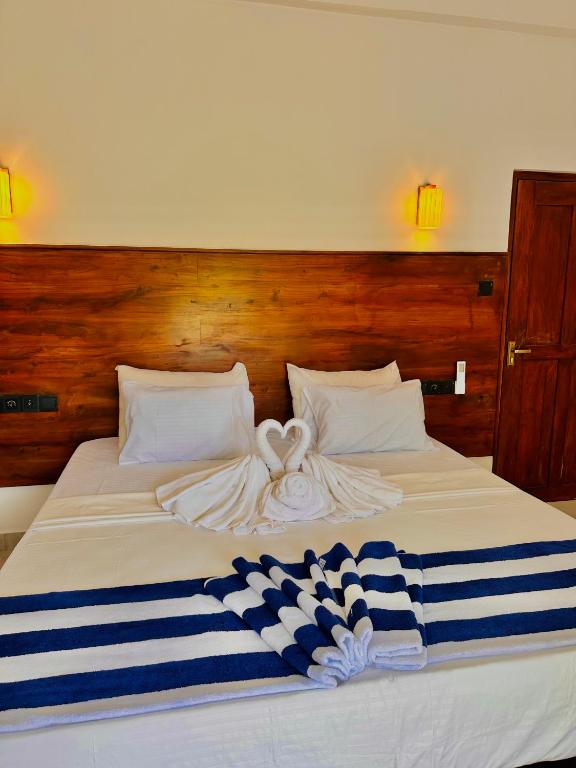 a bed with a blue and white towel on it at In Dream Villa in Rekawa