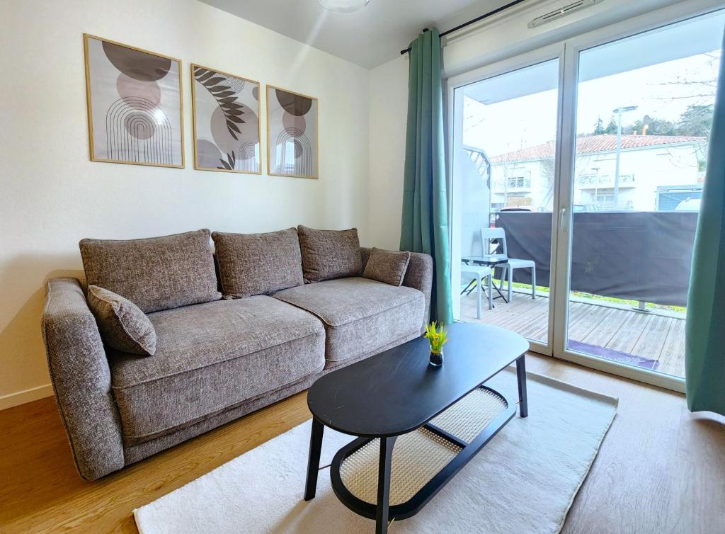 a living room with a couch and a table at Le Silvestre in Bouliac