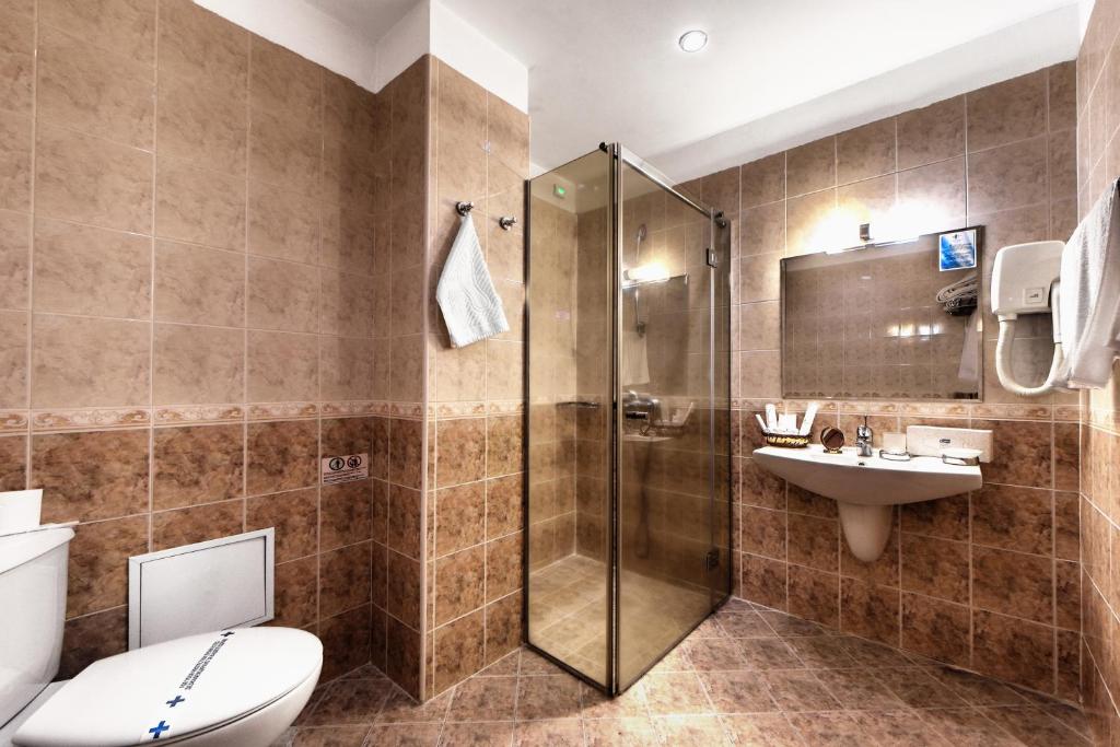 een badkamer met een douche, een toilet en een wastafel bij Спа Хотел Орфей in Devin