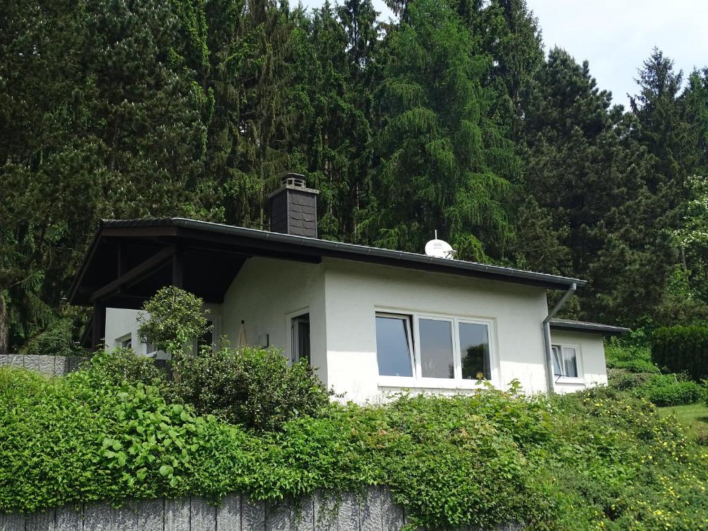 a white house with a chimney on top of a wall at Landhaus Waldrand in Biersdorf am See