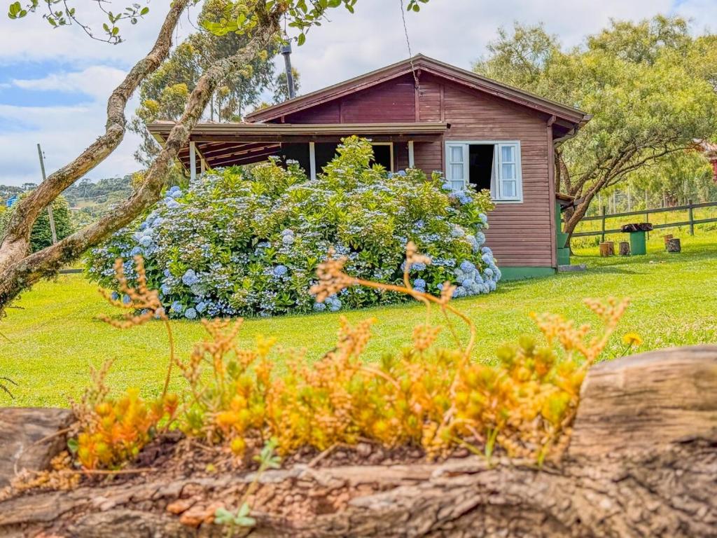 a small house with flowers in front of it at Refúgio do Vale in Urubici
