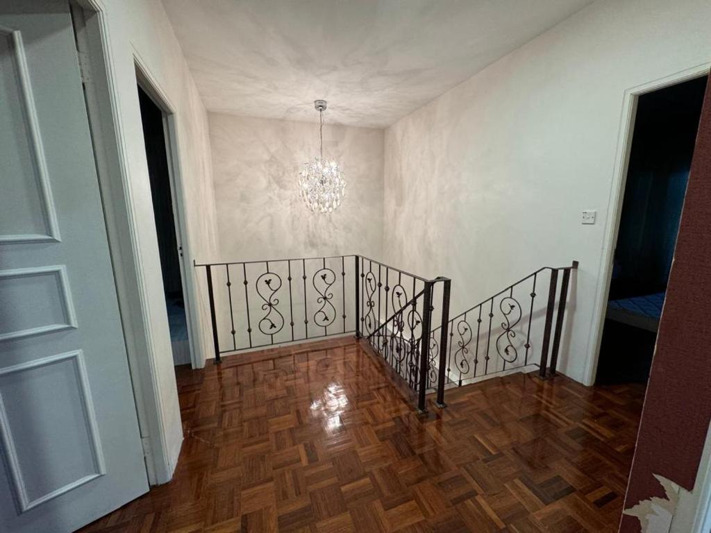 a hallway with a staircase with a chandelier at The Luxe Stay in Kuching