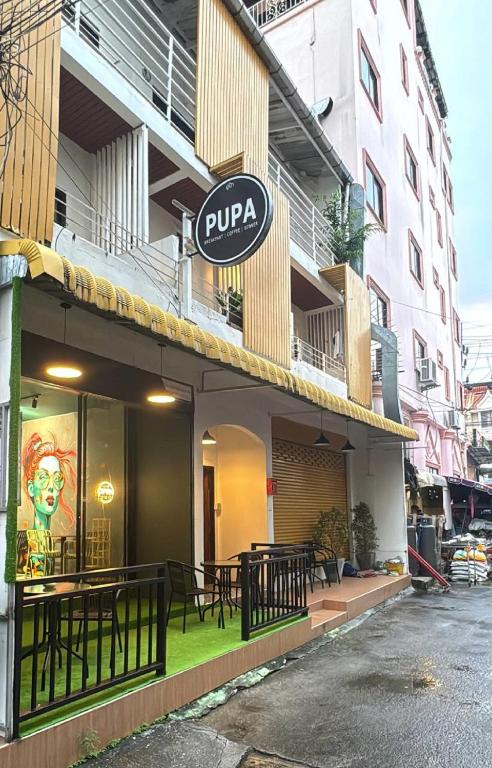 a restaurant with a sign on the side of a building at Pupa Women Hostel in Patong Beach