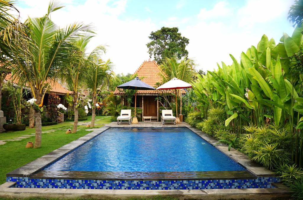 a swimming pool in the yard of a villa at Nauna Villa Bali in Ubud