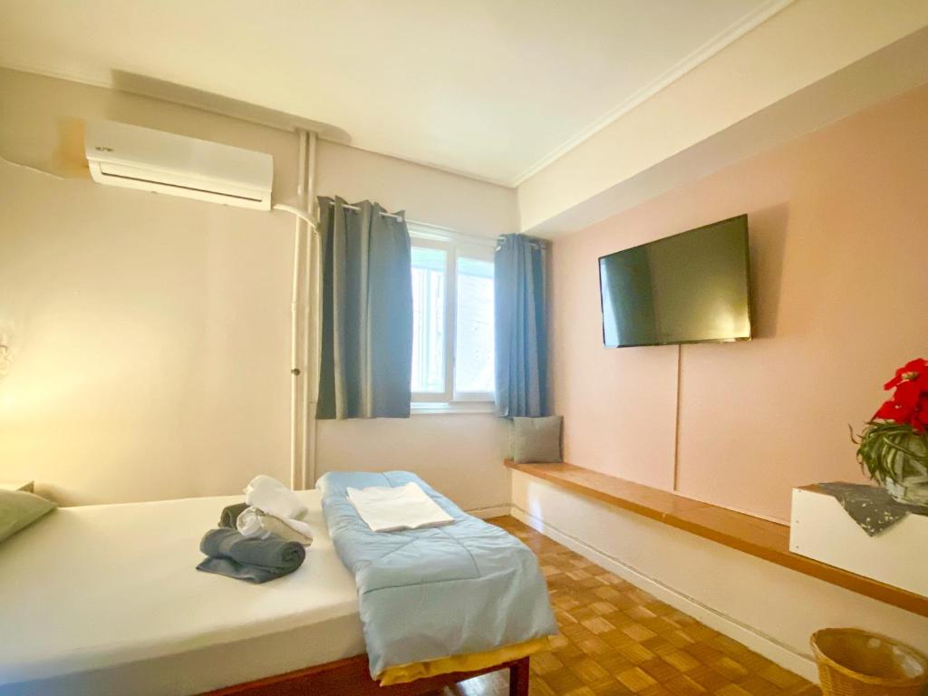 a hotel room with a bed and a tv at Μικρό διαμέρισμα 20μ από την κεντρική πλατεία in Kalamata