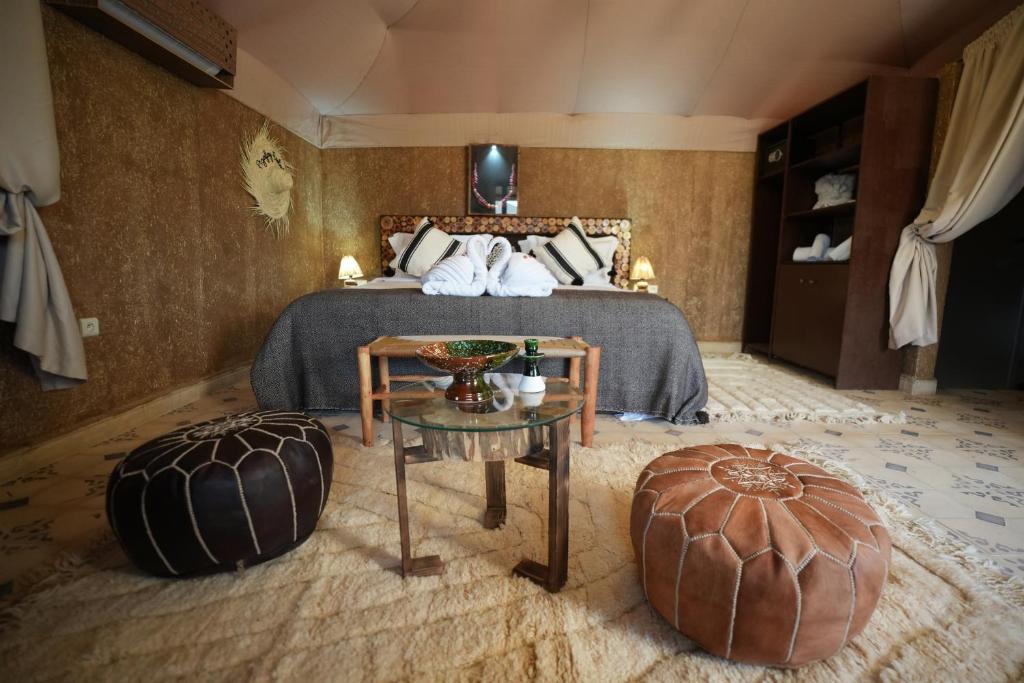 een hotelkamer met een bed en een tafel bij Agafay Ecolodge in Aït Mazou