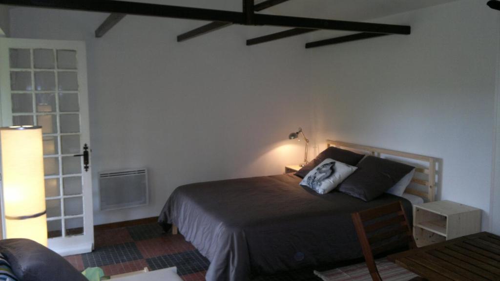 a bedroom with a bed with two pillows on it at La Cabane des Beaux Chênes in Évrunes