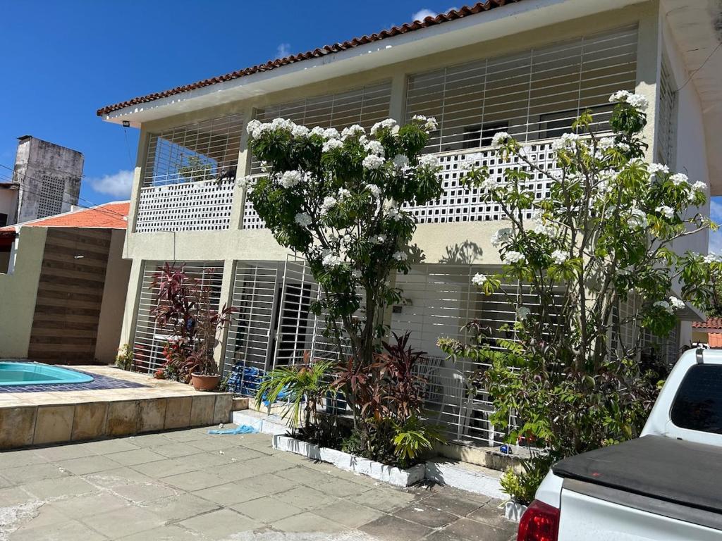 a house with a window with blinds on it at Casa ampla e completa a poucos passos da praia! in Itamaracá