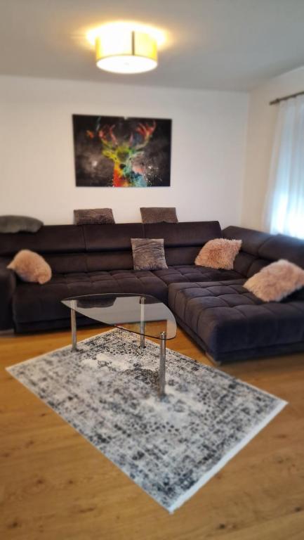 a living room with a couch and a glass table at Ferienwohnung Claudia Alt-Ossiach in Altossiach
