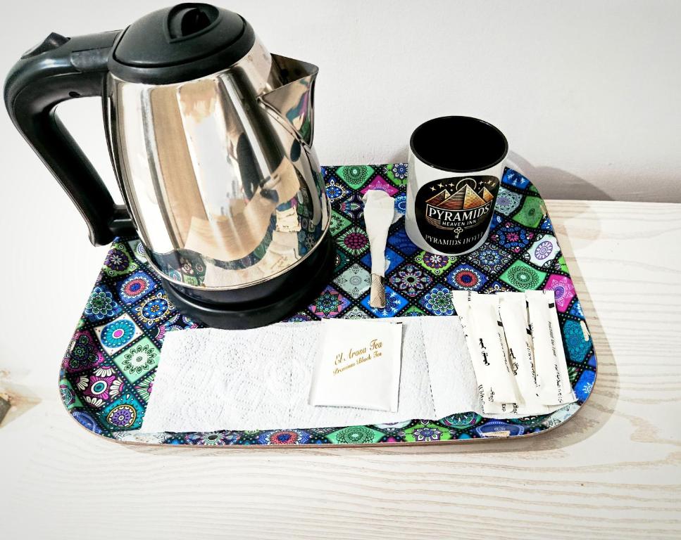 een waterkoker en een kop koffie op een bord bij Pyrs Giza Heaven in Caïro