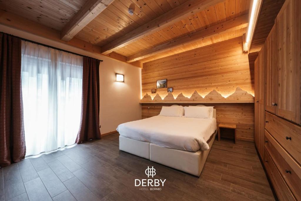 een slaapkamer met een bed in een houten kamer bij Hotel Derby in Bormio