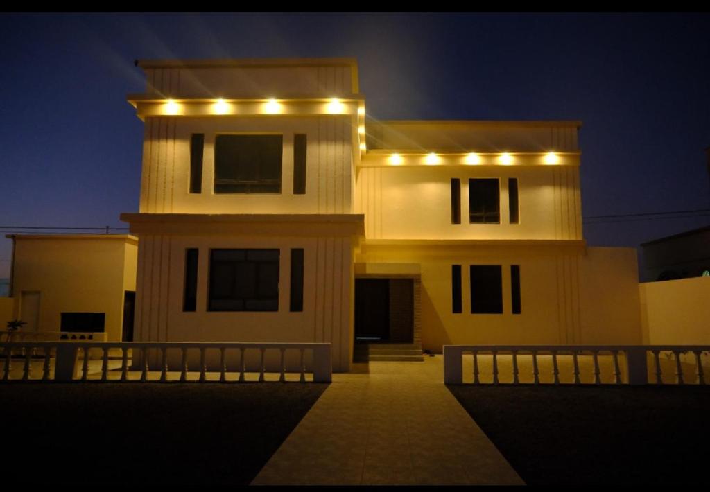 een huis met 's nachts lichten erop bij Pink Beaches Guest Houses in Al Ḩadd