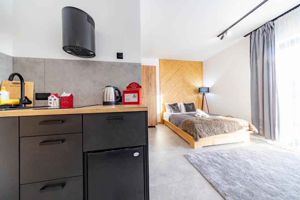 een keuken met een bed in de hoek van een kamer bij ApartRoom 18 in Zakopane