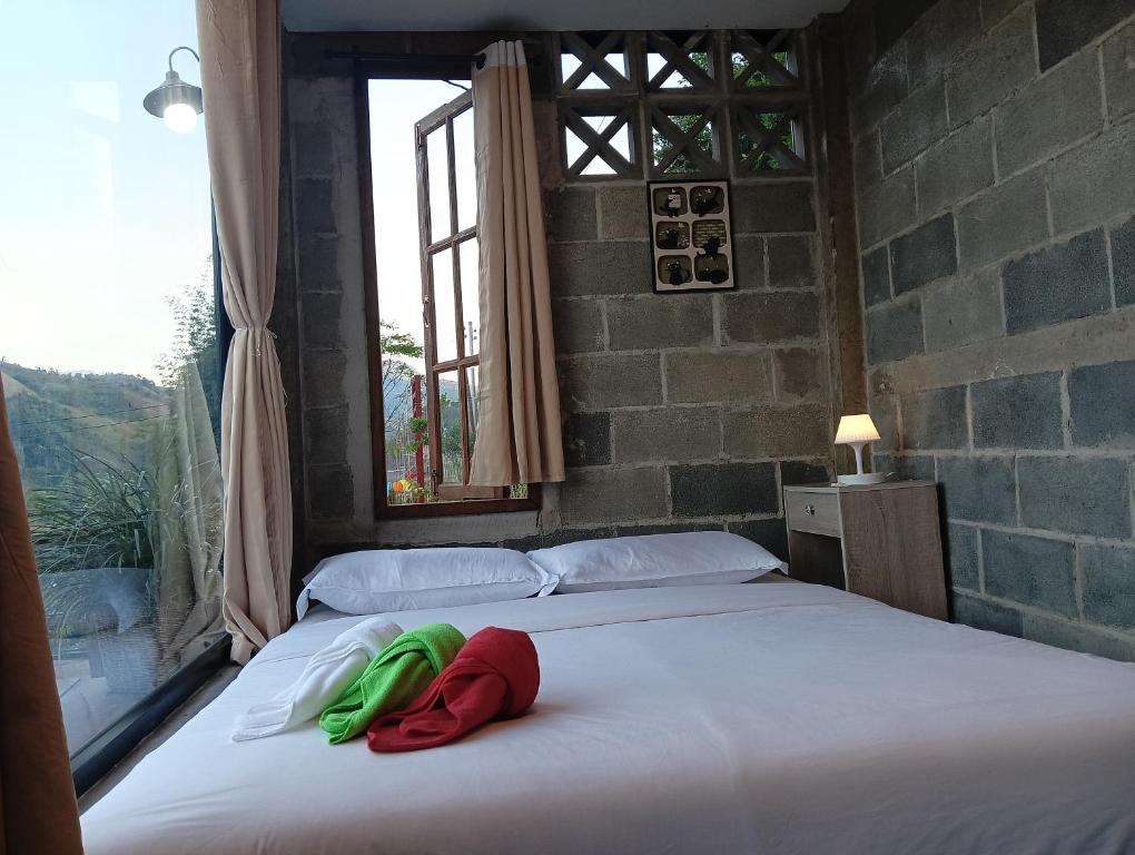 een bed met rode en groene handdoeken erop bij บ้านนอร์ดบล็อกเวนิสบ้านเวร in Ban Khun Nam Nan