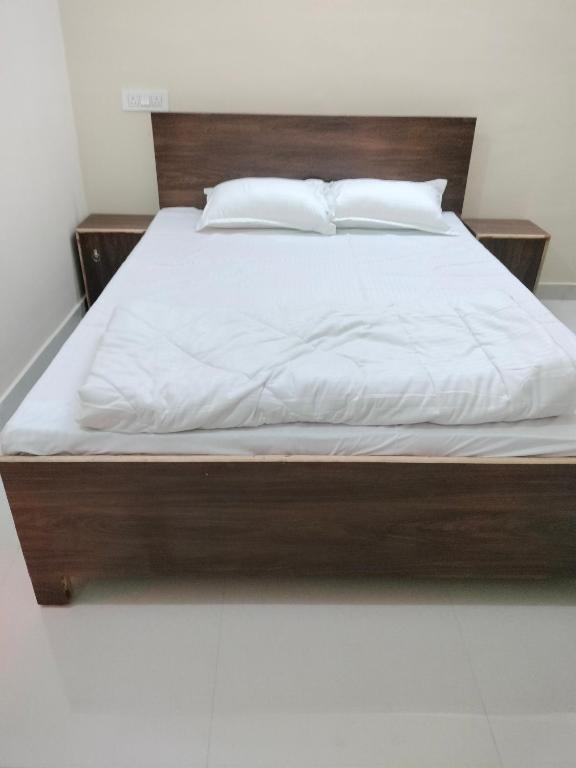 a bed with white sheets and pillows on it at Hotel Krishn Residency in Garwa Road