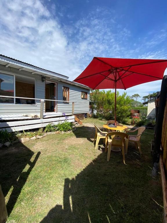 a patio with a table with a red umbrella at TINY HOUSE Refugio de Mar in Mar del Plata
