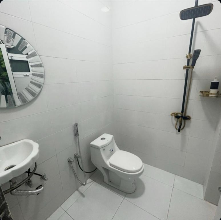 een witte badkamer met een toilet en een wastafel bij فندق وادي السحتن in Al Ambaḩ