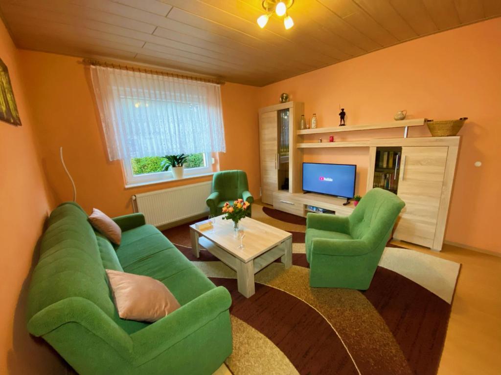 een woonkamer met een groene bank en 2 groene stoelen bij Ferienwohnung Landmannsruh in Lubmin