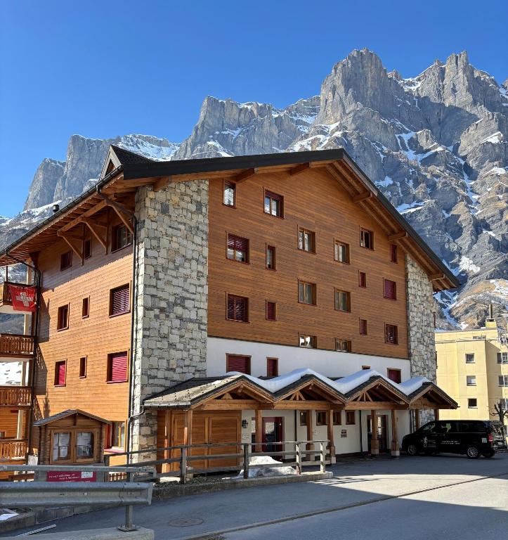 a large building with a mountain in the background at Residenz Darianne Leukerbad in Leukerbad