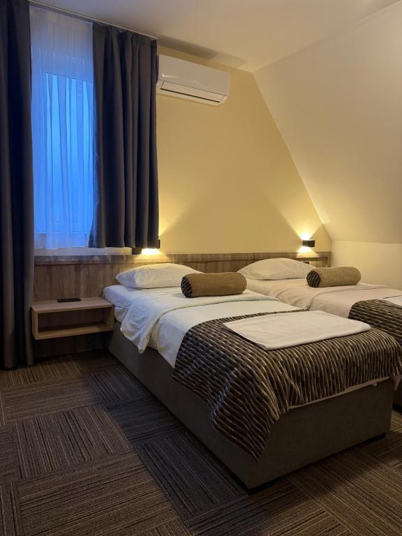 twee bedden in een kamer met een raam bij Hotel Previla in Sarajevo