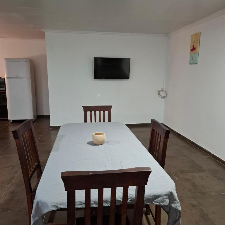 a dining room with a table with chairs and a television at very spacious house equipped for 4 people in Resistencia