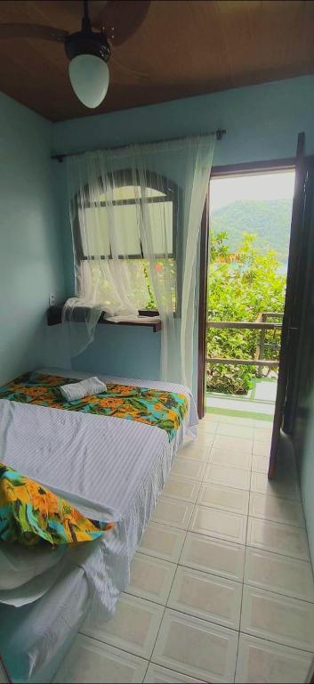 a bedroom with a bed and a window with a view at Pousada Toca do Mar in Praia de Palmas