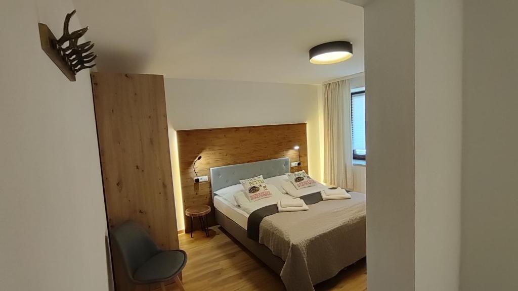 a bedroom with a bed and a chair at Pension Bergblick in Ruhpolding