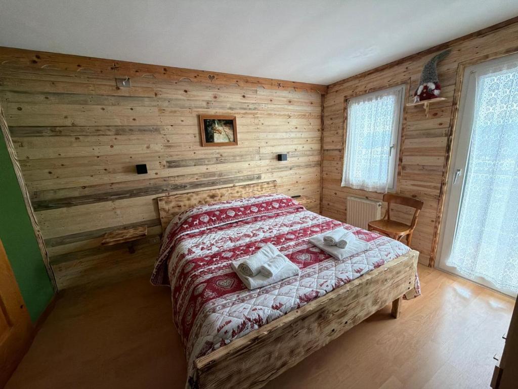 een slaapkamer met een bed in een houten wand bij Albergo Ristorante K2 in Roana