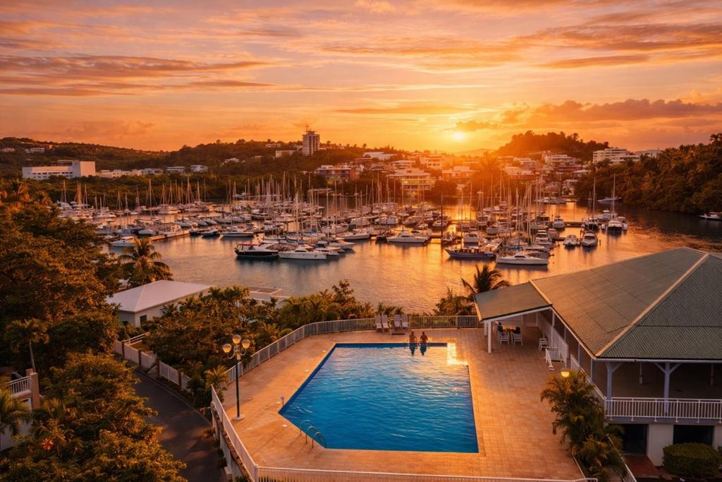 een zwembad voor een jachthaven met boten bij L Opacarophile Studio Marina du Gosier in Le Gosier