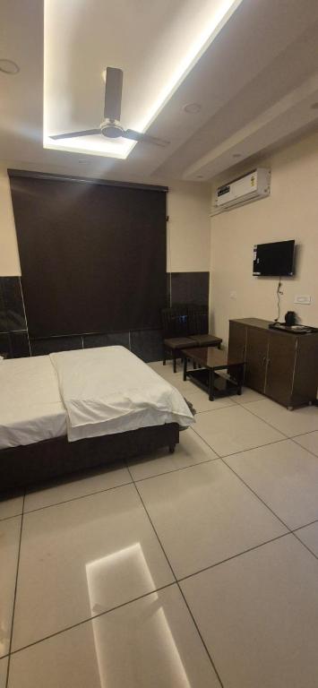a bedroom with a bed and a tv on the wall at Hotel inn de dogras in Udhampur
