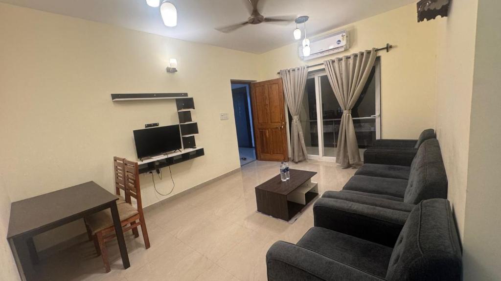 ein Wohnzimmer mit zwei Sofas und einem Fernseher in der Unterkunft Rosebank service Apartment in Arpora