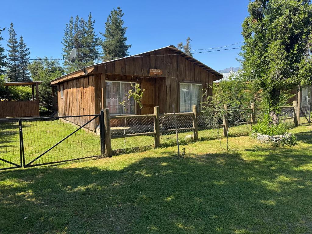 een schuur met een hek voor een tuin bij Cabañas Granja Paraíso in Molina