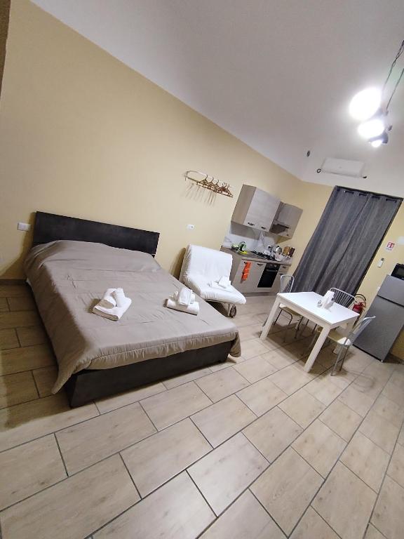a bedroom with a bed and a table in it at Sicilian Room in Catania