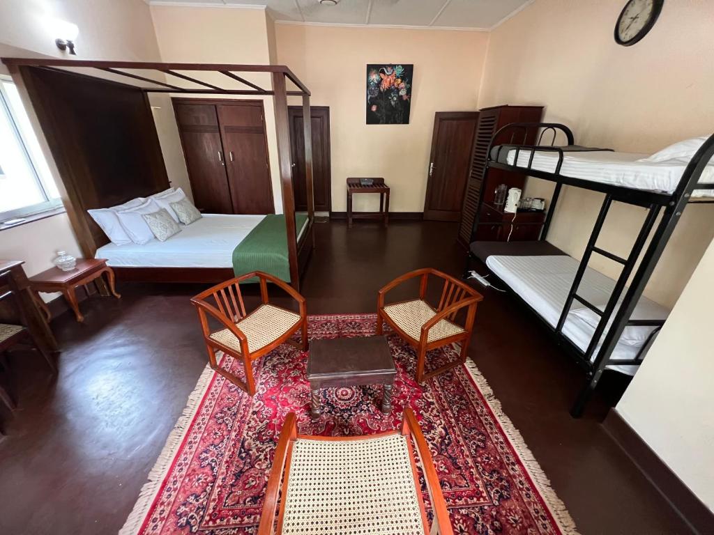 a room with two bunk beds and a table and chairs at The Deane Residence Family Room in Colombo