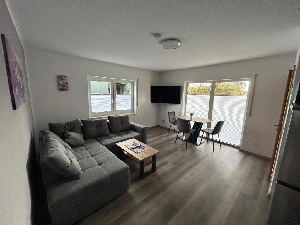 een woonkamer met een bank en een tafel bij Ferienwohnungen zur Elsa in Waldeck