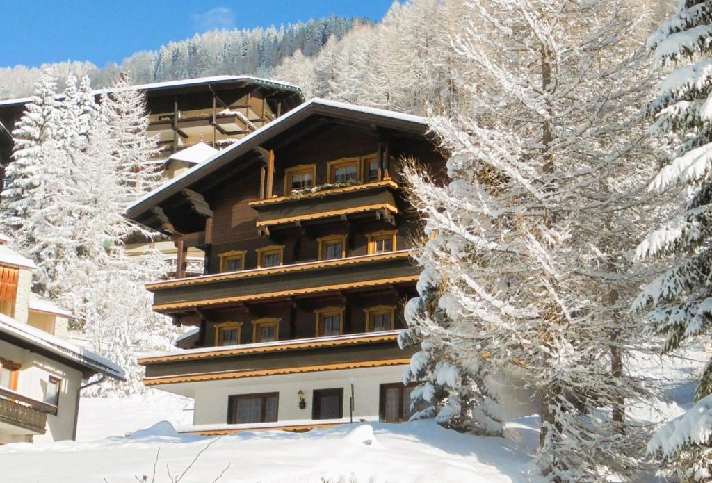 een groot gebouw in de sneeuw met sneeuw bedekte bomen bij Ferienhaus Unterkircher-Wallner in Heiligenblut
